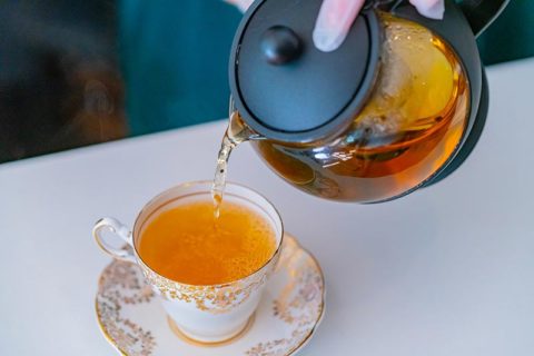 Pot of tea being poured into teacup at Freedom Society