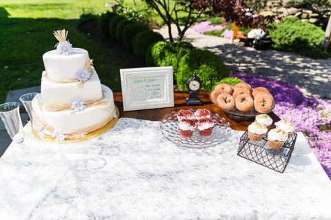 Table with cake, donuts, and cupcakes by Lil Tea's