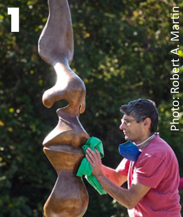 artist polishing the sculpture "Beacon"