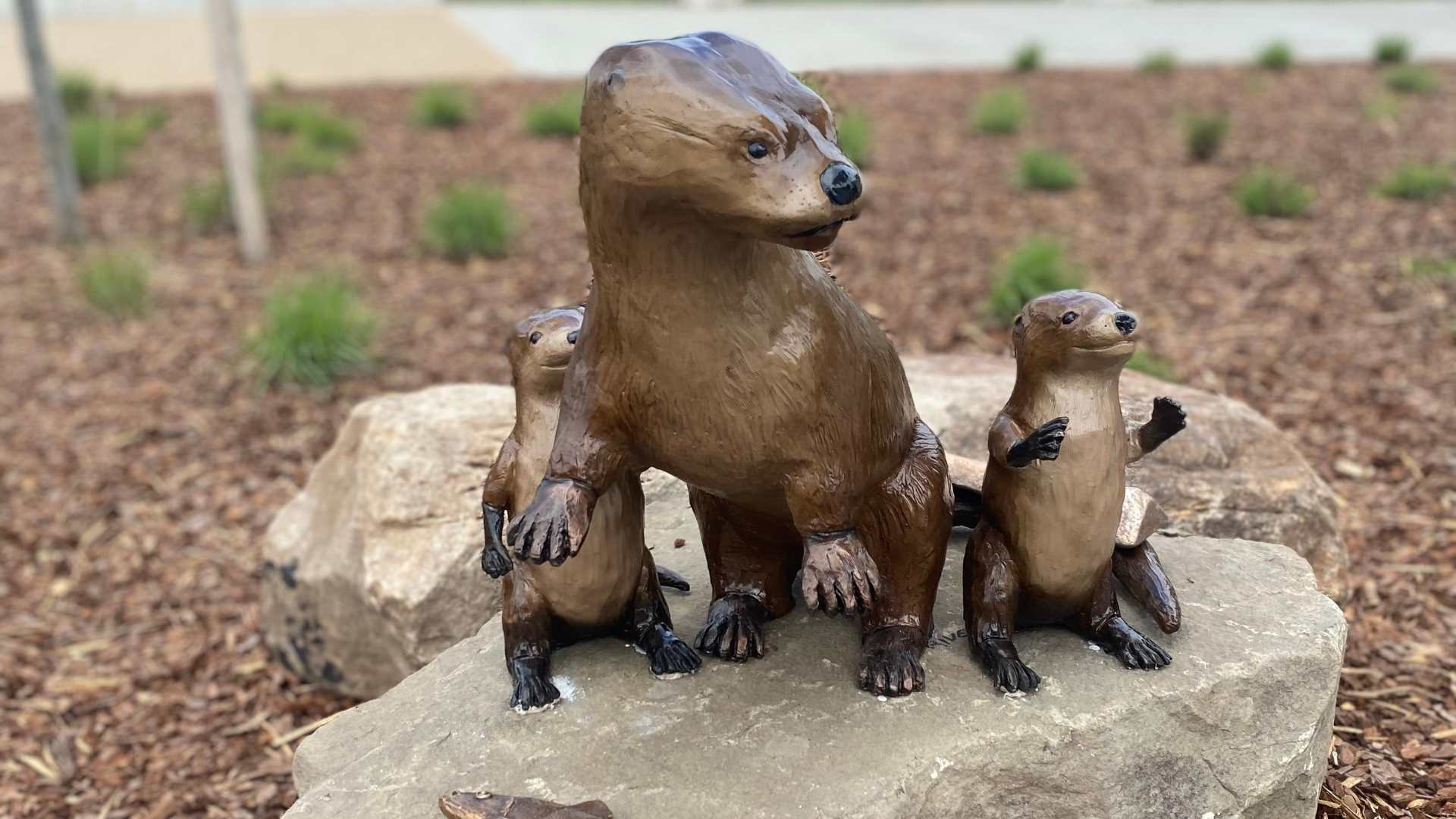 momma otter and 2 pups bronze statues looking to the right