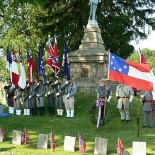 soldiers holding flags at the confederate cemetery