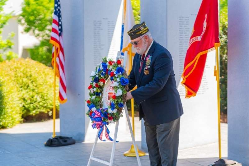 soldier placing wreath at fallen heroes war memorial