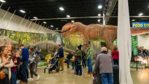 dinosaur looking over people at the fredericksburg expo center