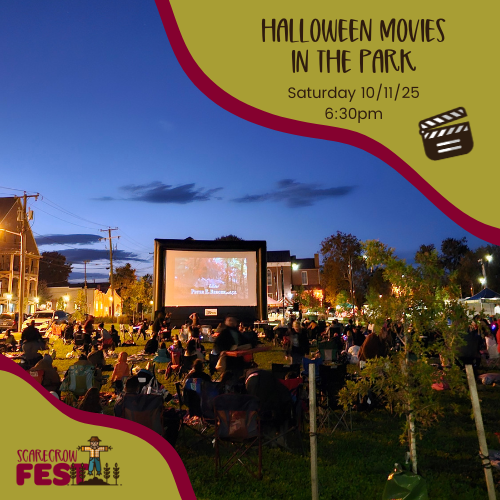 A movie screen with a crowd of people watching it in a park.