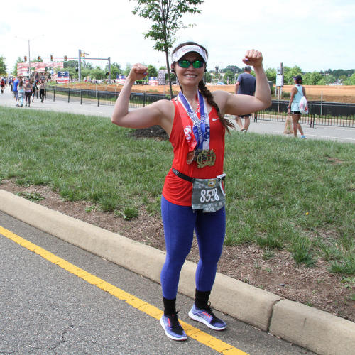 Lady showing off her medals after the Marine Corps Historic Half