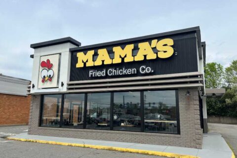 Dark black building with windows on the bottom half. Yellow text reads 'MAMA'S' white text reads 'Fried Chicken Co.' Picture of chicken with white background on the left side of the building.