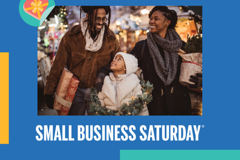 Small Business Saturday November 25 in white on the dark blue sky with small shop buildings at the bottom in white