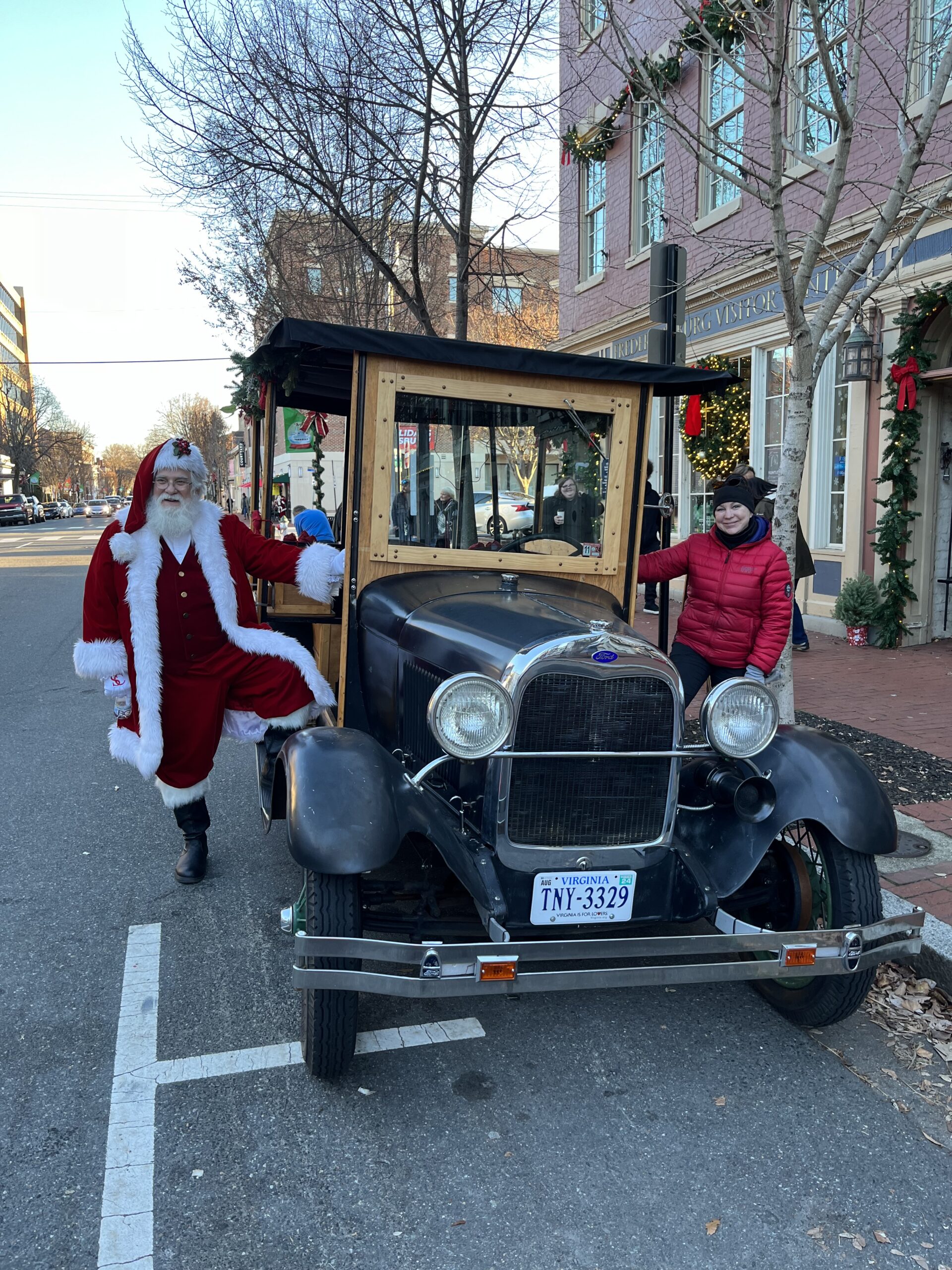 Santa and tour drive posing on each side of a model a tour