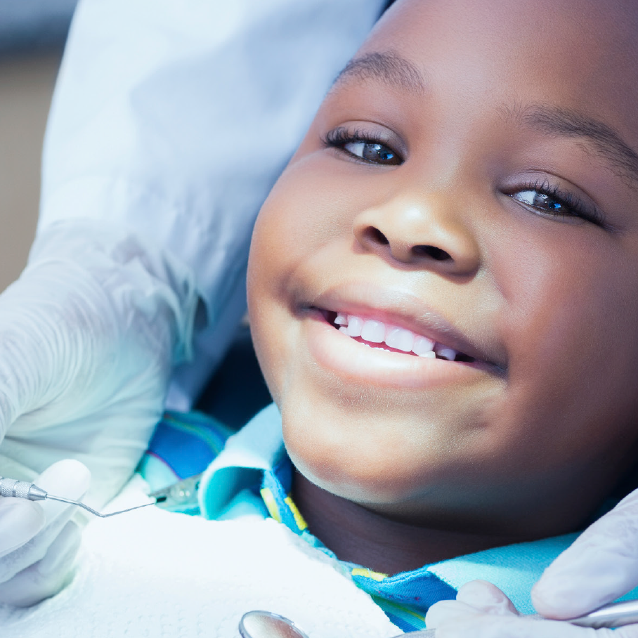 child smiling while getting his teeth cleaned