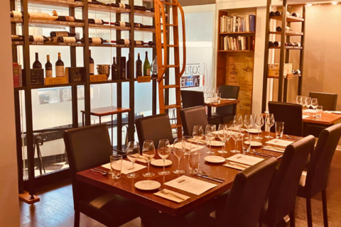 set table for 6 inside of cork and table restaurant with racks of wine in the background