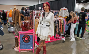 Girl posing in front of her booth of vintage items at the Thrift World Expo.