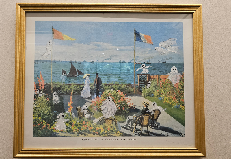 A Claude Monet painting of people and dogs in a garden by the water. As part of the upcycled art show entry, it has ghosts painted over the people.