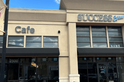The front of a coffee shop that says Success Cafe