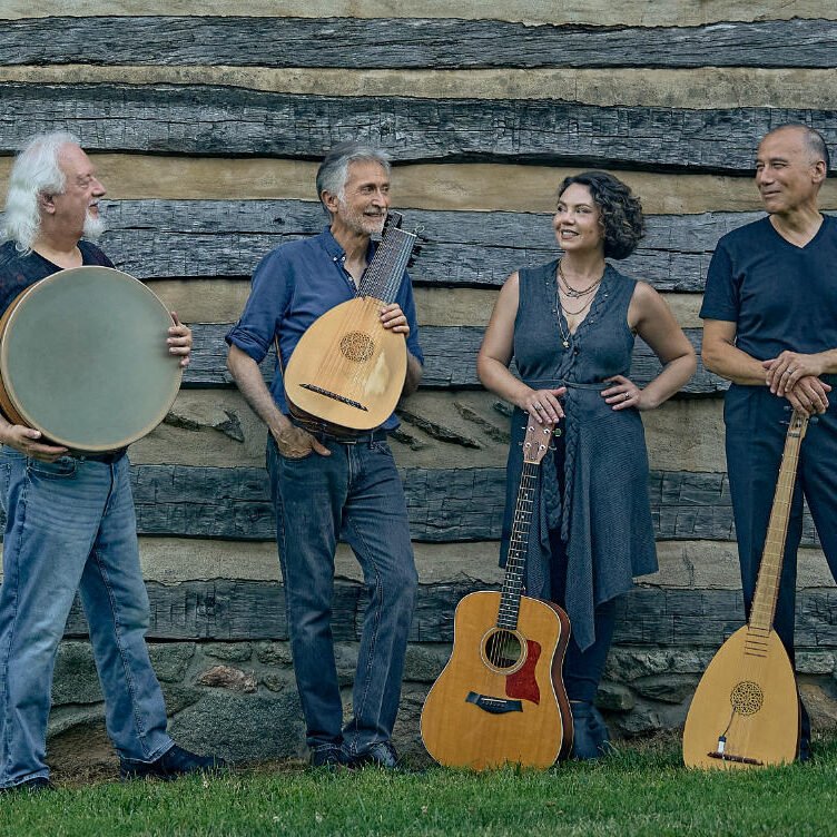 ayreheart photo Three men and a woman holding instruments and smiling at each other.