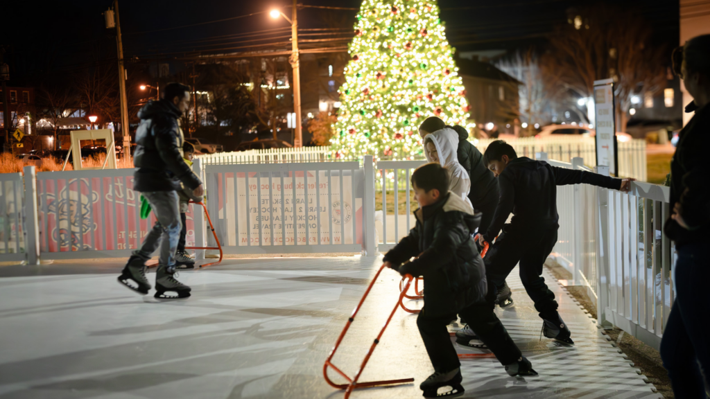Children Ice Skating in front of a large Christmas tree at Riverfront Park.