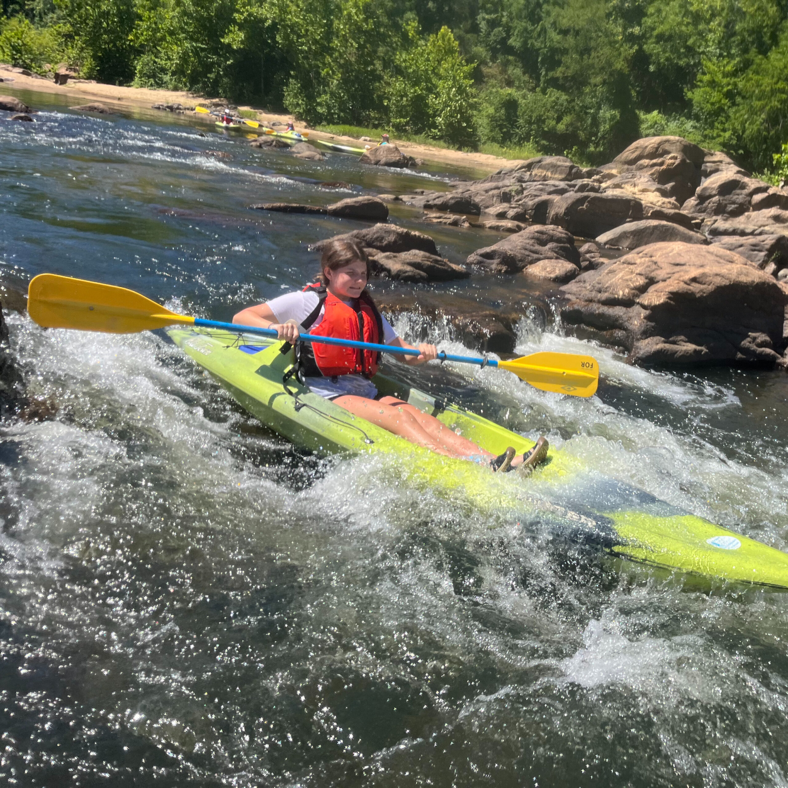 Kid kayaking on the river.