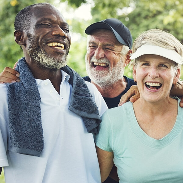 3 elderly people smiling and laughing together.