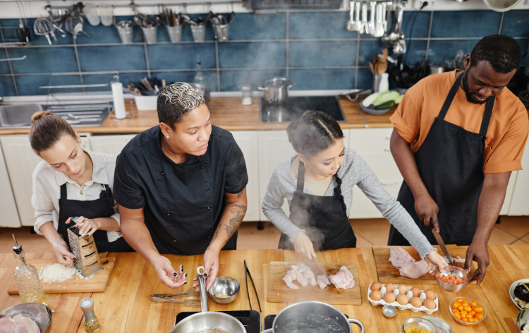 Four people cooking in a class