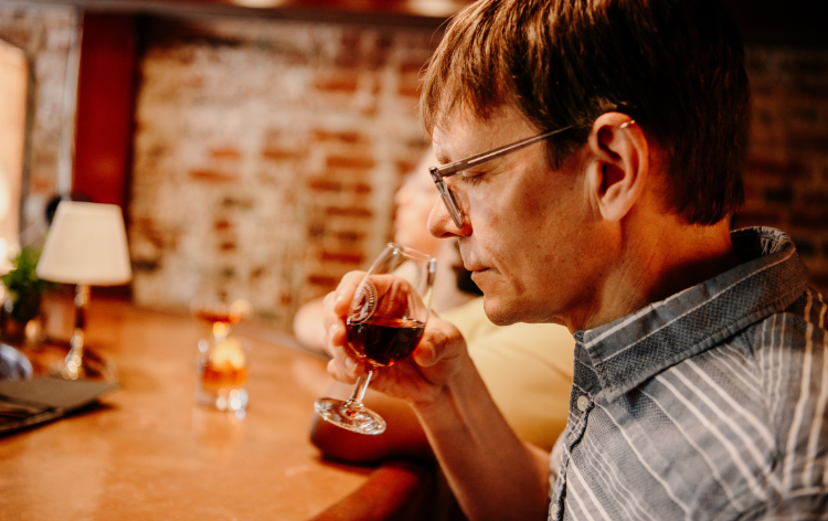 A man sniffing a glass of bourbon at ironclad
