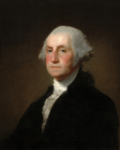 A formal portrait painting of George Washington wearing a dark coat, a white ruffled shirt, and a powdered wig. He has rosy cheeks and a serious expression.