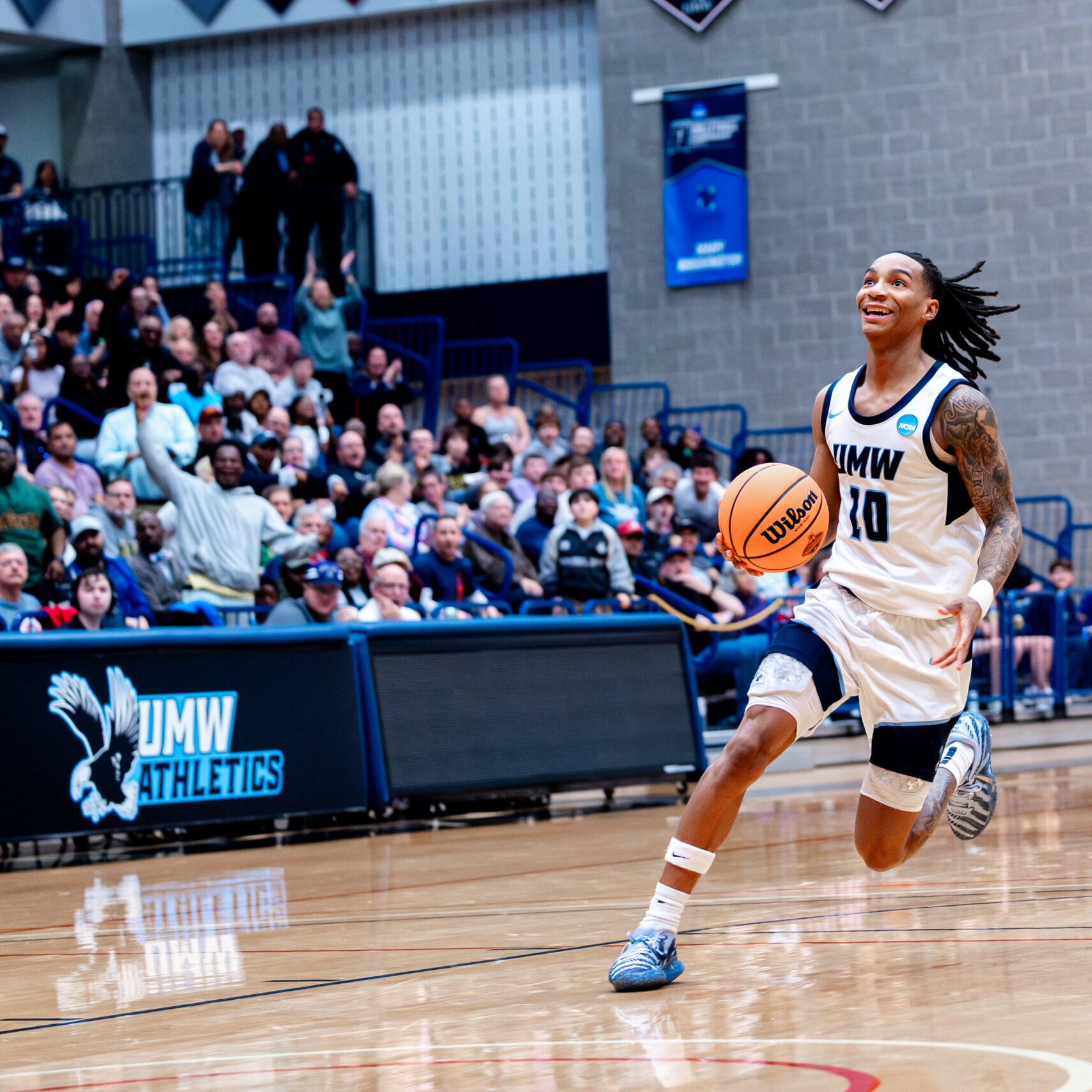 UMW basketball player dribbling down the court.
