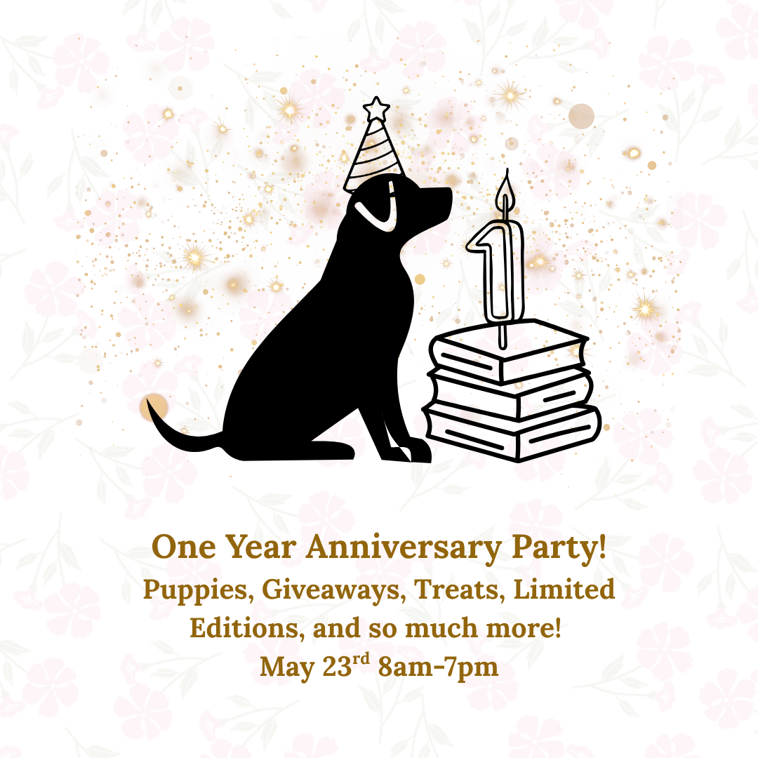 Flyer for a “One Year Anniversary Party” featuring a black silhouette of a dog wearing a party hat, sitting next to a stack of books topped with a candle shaped like the number one. The background includes soft floral patterns and gold confetti accents. Text reads: “One Year Anniversary Party! Puppies, Giveaways, Treats, Limited Editions, and so much more! May 23rd, 8 am–7 pm.”