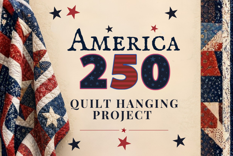A close-up of a quilt with a patriotic design featuring red, white, and blue stripes and stars. A border of patchwork squares in similar colors runs along the right side of the image.