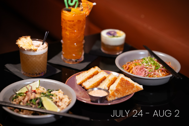 A spread of food and drinks including two cocktails, a bowl of noodles, a bowl of rice, and grilled cheese sandwiches with dipping sauce.
