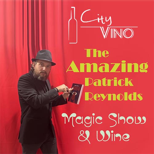 Stage with a red curtain with a magician holding a book at center stage.